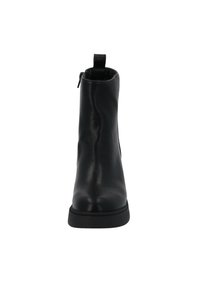 Botte mi-mollet en cuir noir avec bout rond, semelle épaisse, fermeture éclair latérale et languette à l’arrière, vue de face.