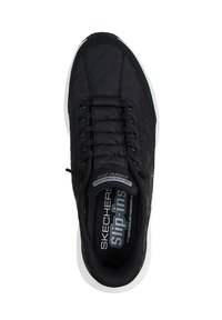 Zapatilla negra sin cordones con parte superior acolchada, puntera redonda, diseño de cordones y suela blanca con un patrón texturizado para mayor agarre.