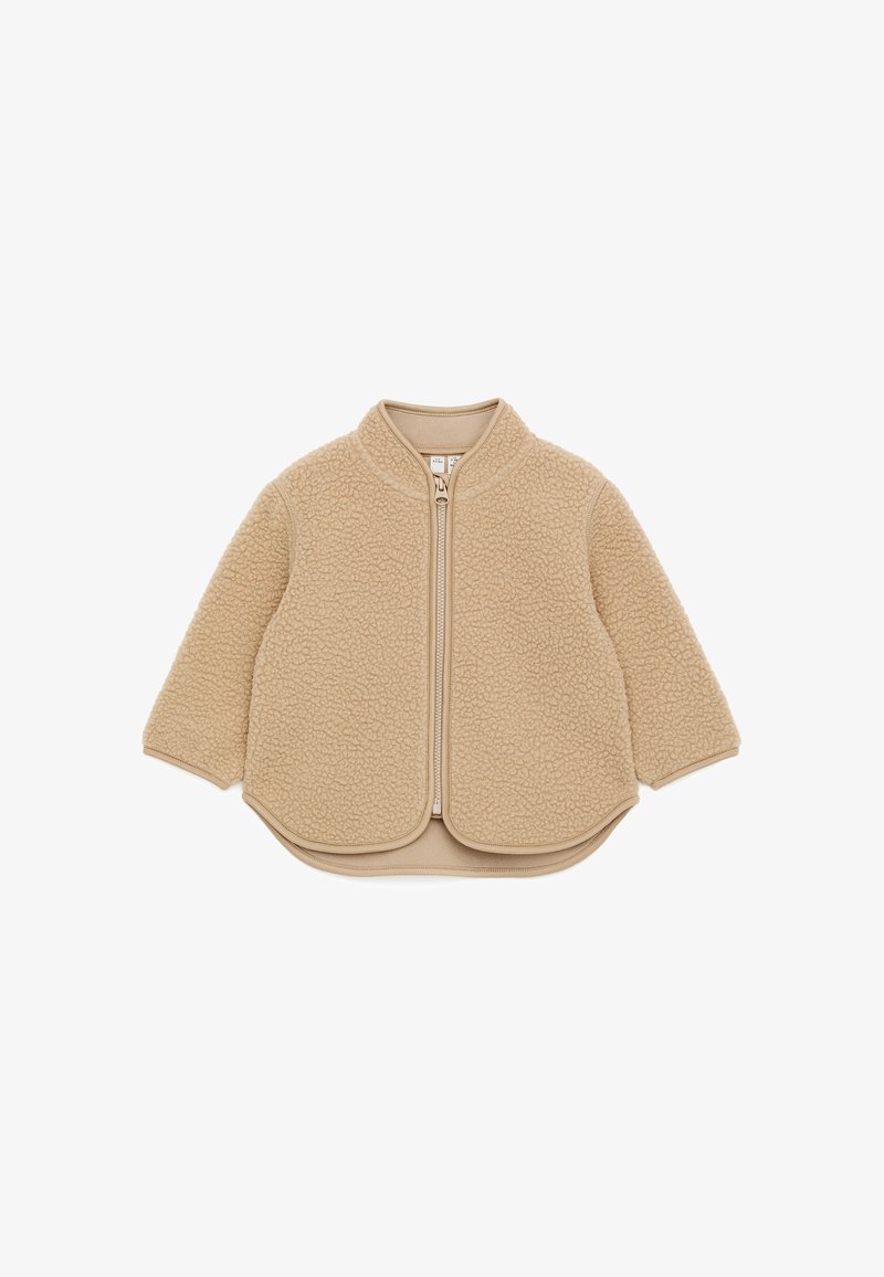 Veste beige pour tout-petit avec fermeture éclair, en polaire douce et texturée, manches longues et ourlet arrondi.