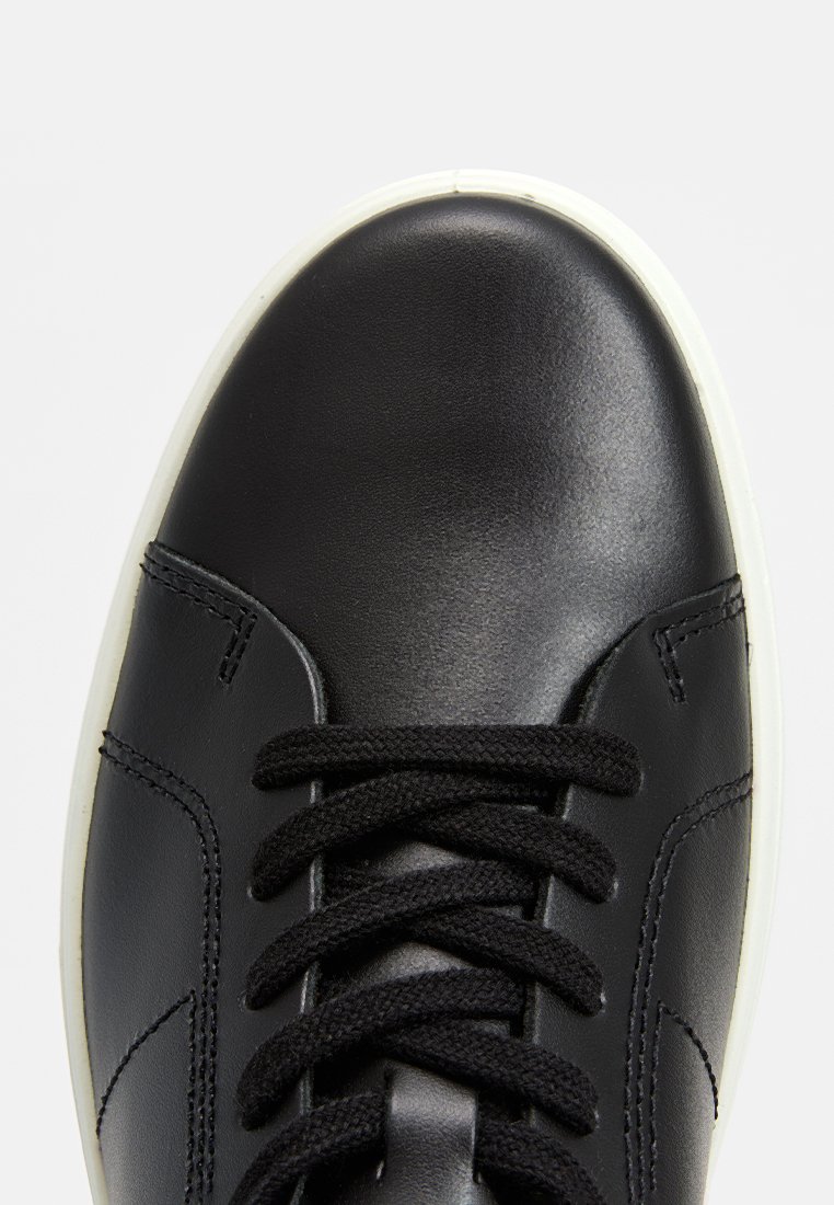 Czarne skórzane sneakersy o gładkim wykończeniu, tradycyjnym zapięciu na sznurowadła i białej gumowej podeszwie. Szczegóły przeszyć po bokach.