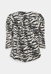 Blusa a maniche lunghe con stampa astratta in bianco e nero, tessuto strutturato, scollatura rotonda e leggere pieghe sul retro.