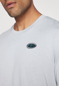 Under Armour HEAVYWEIGHT LEFT CHEST PATCH - Basic T-shirt - mod gray medium heather/black