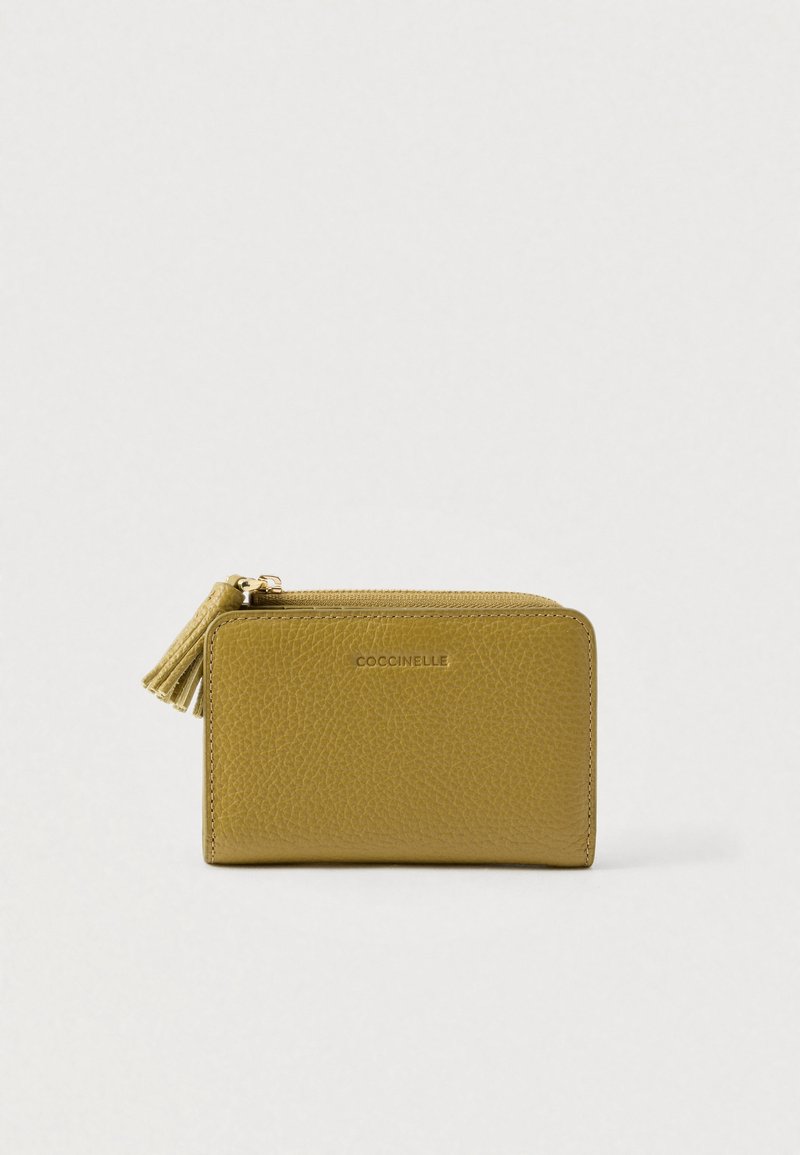 Compact textured mustard yellow leather wallet with zipper and tassel pull, embossed with brand name "Coccinelle" on front center.