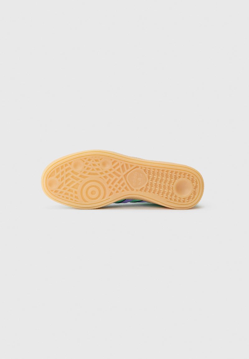 Shoe sole with a textured surface, featuring a light orange rubber material with circular and geometric patterns.