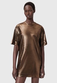 Bronsfärgad metallisk oversized t-skjortklänning med korta ärmar, rund halsringning och en mjuk textur. Sitter ovanför knäet och reflekterar ljus.