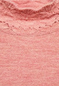 Soft pink knitted fabric with a ribbed collar and delicate lace-like pattern along the neckline.