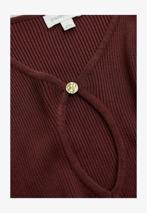 Burgundia soontekkidega sviiter V-kujulise kaelusega ja ümmargune, tekstuuriga kuldne nupp, mis rõhutab esiosa. Pehme kudumaterjal ja vormitud disain.