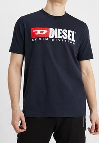 Navy blue cotton t-shirt with round neckline, featuring a bold red and white "DIESEL DENIM DIVISION" logo on the front. Short sleeves.