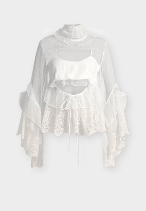 Διάφανη λευκή μπλούζα με βολάν στον ψηλό λαιμό, φουσκωτά μανίκια από δαντέλα, εσωτερικό στρώμα cropped και λεπτομέρεια ζώνης με κορδόνι στη μέση.