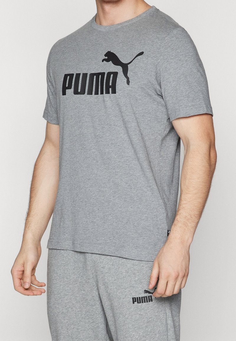 Grå bomulds t-shirt med korte ærmer, der har et fremtrædende sort "PUMA" logo og et springende puma grafik henover brystet.