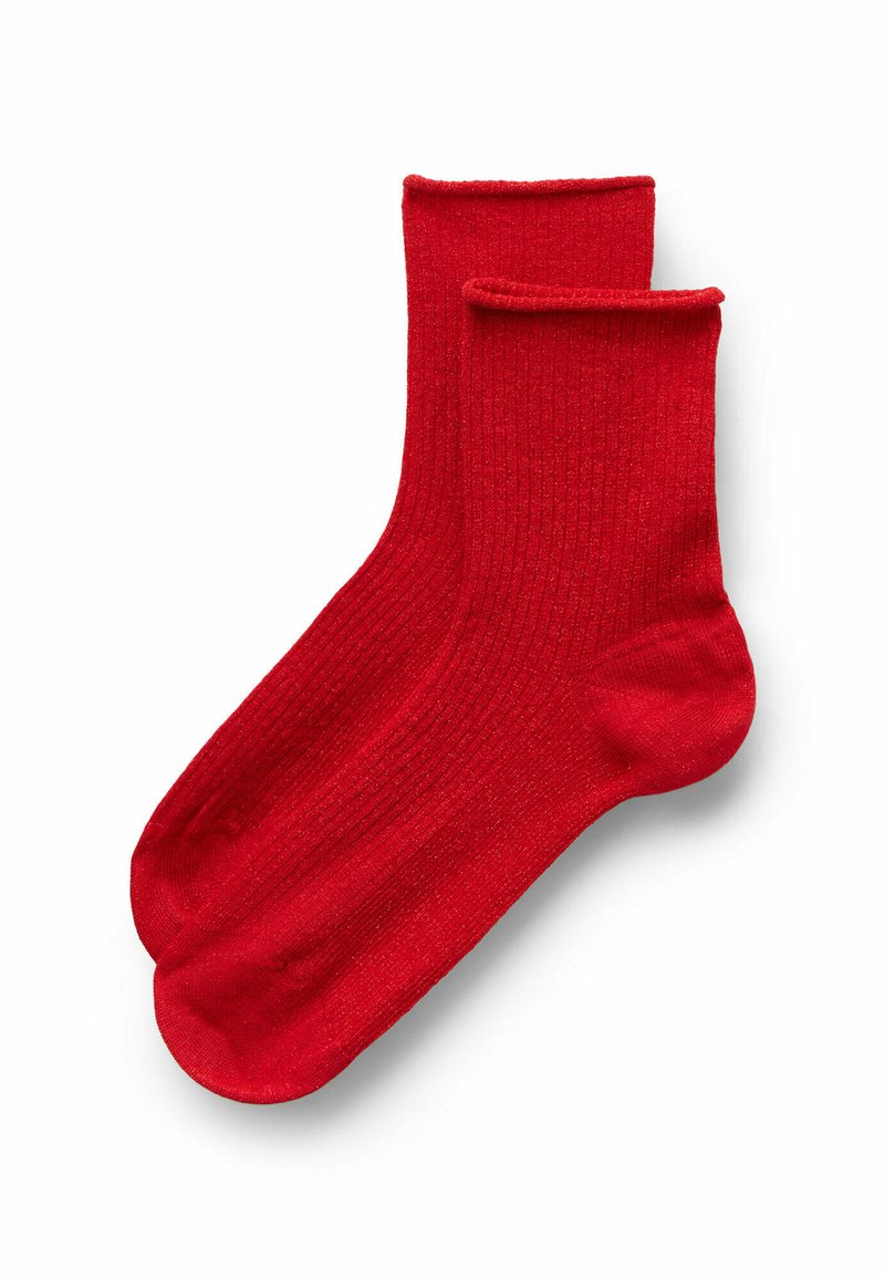 Un paio di calzini alla caviglia a righe di colore rosso brillante con polsini piegati su uno sfondo bianco.