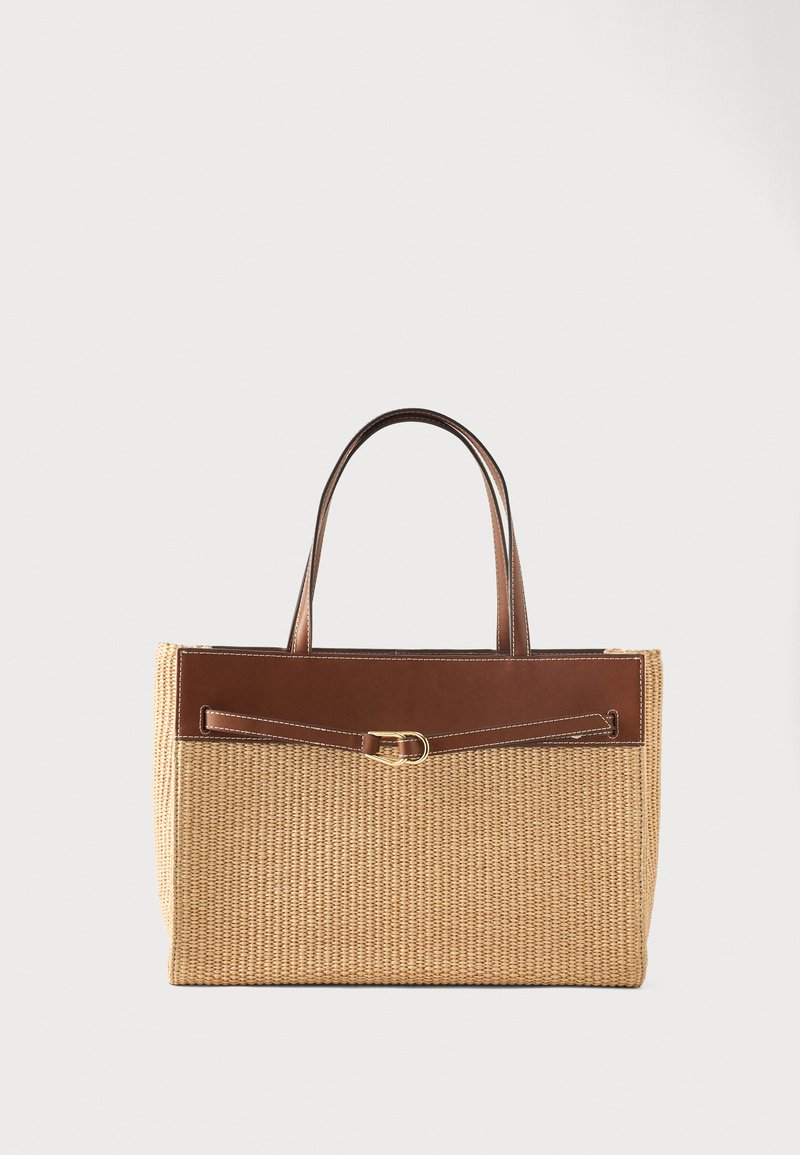 Ορθογώνια υφαντή τσάντα από ψάθα με καφέ δερμάτινη επένδυση, λεπτή ζώνη και δύο δερμάτινα χερούλια, σε απλό ανοιχτό φόντο.