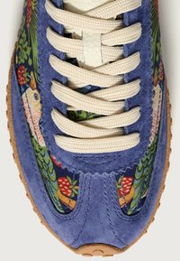 Sneaker multicolore con tomaia in suede blu, motivo floreale in tessuto, lacci color crema e suola in gomma marrone testurizzata.