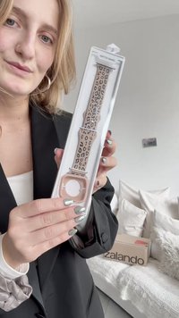 Pas leopardega vzorca v svetlo roza barvi z mehko teksturo. Vsebuje ujemajočo se kvadratno ohišje ure v prozornem pakiranju.