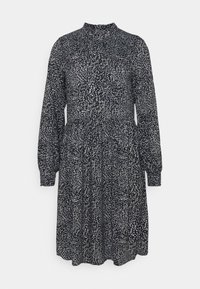 Sukienka z długim rękawem w czerni i bieli, z wzorem przypominającym liście, wysokim dekoltem, dopasowaną talią i rozszerzanym dołem z kieszeniami.