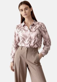 Long-sleeve pink blouse with abstract wave pattern in contrasting beige, featuring a collared neckline and button-down front.