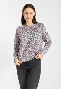 Grijze trui met roze en zwarte luipaardprint; ronde hals, lange mouwen, geribde manchetten en onderkant. Draag met donkere spijkerbroek.