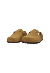Brown suede clogs with a rounded toe, adjustable strap, and textured sole, featuring a natural finish and minimalist design.