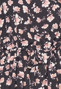 Musta kangasmekko, jossa on vaaleanpunaisia ja valkoisia kukkakuoseja, varustettuna rypytetyllä vyötäröllä ja nyörityksellä säädettävää istuvuutta varten.