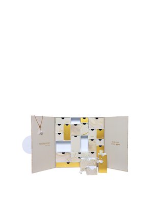 Adventskalender mit mehreren goldenen und beigen nummerierten Schubladen, einige geöffnet, die Schmuckstücke und eine innen hängende Halskette zeigen.
