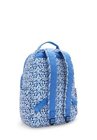 Mochila azul con un patrón geométrico blanco, correas de hombro acolchadas y un asa en la parte superior. Dos bolsillos laterales para almacenamiento adicional.