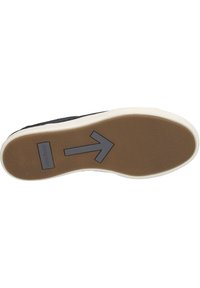 Semelle de sneaker noire avec une base en caoutchouc texturé beige. Semelle intermédiaire en caoutchouc blanche et un logo flèche directionnelle grise en bas.