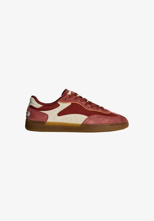 Zapatilla baja con paneles de gamuza burdeos y blanco roto, cordones a juego y suela de goma translúcida, mostrada desde el lado exterior.