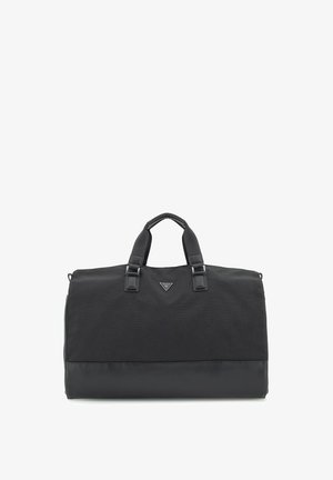 Sac de voyage noir avec une partie supérieure en textile et une base en cuir lisse. Deux poignées supérieures et un accent logo triangulaire à l'avant. Forme rectangulaire, fermeture zippée.