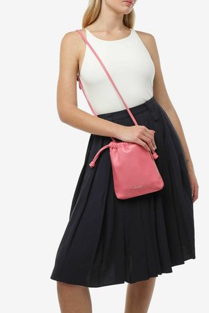 Borsa a tracolla in pelle rosa con cordoncino e tasca con zip. Forma compatta, texture liscia e dettaglio di branding discreto sul davanti.