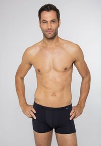 Svarta boxershorts i mjukt, strukturerat tyg med horisontella ränder. Har en figursydd design och en liten logotyp på midjan.