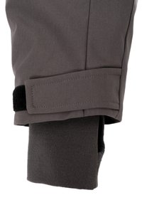 Detailní záběr na šedou manžetu bundy s nastavitelným suchým zipem a vnitřní černou pletenou zápěstní manžetou.