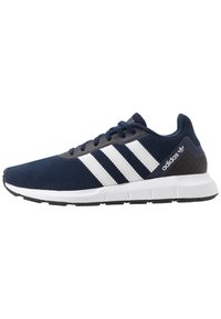 Marineblaue Adidas Sneaker mit weißen Streifen, Obermaterial aus Mesh, gepolsterter weißer Sohle, schwarzem Außensohle und Adidas-Logo auf der Ferse.