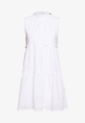 Robe blanche sans manches en œillet, col haut et jupe à volants, avec un petit motif de découpe circulaire sur l'ensemble du tissu.