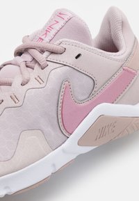 Sneaker Nike con tomaia in morbido mesh rosa, dettagli in suede, logo swoosh rosa e suola in gomma bianca con dettagli testurizzati.