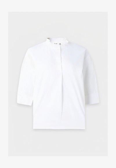 Blouse blanche avec manches trois-quarts et petit col montant, patte de boutonnage dissimulée à l'avant, design uni.