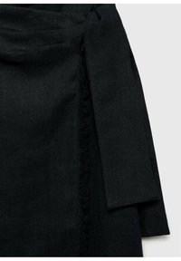 Manteau portefeuille en lin noir avec une finition texturée, doté d'une large ceinture nouée et de bords frangés pour plus de détails. Design simple et moderne.