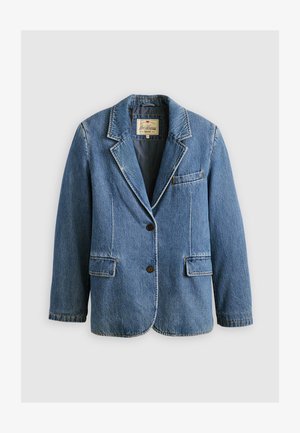 Világoskék farmerblézer, hajtókás gallérral, két elülső zsebbel és egy gombos zárással. Kontrasztos varrással és textúrált felülettel rendelkezik.