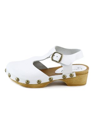 Sandalia blanca de cuero estilo zueco con correa ajustable con hebilla, tachuelas de latón y tacón bajo de madera, vista desde el lado exterior.