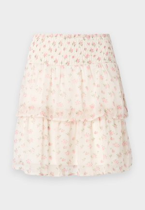 Blomstret lagdelt nederdel lavet af letvægtsstof. Har en smocket talje, lyserøde blomster og en cremefarvet baggrund med en blød, gennemsigtig tekstur.