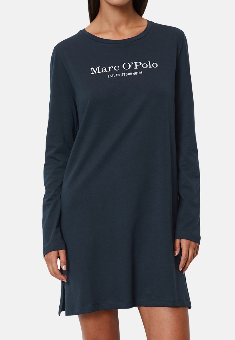 Laivansinisestä puuvillamekosta, jossa on pitkät hihat, pyöreä kaula-aukko ja valkoinen teksti "Marc O'Polo PERUSTETTU STOCKHOLMISSA" etupuolella. Suora leikkaus, reiden keskiväliin saakka.