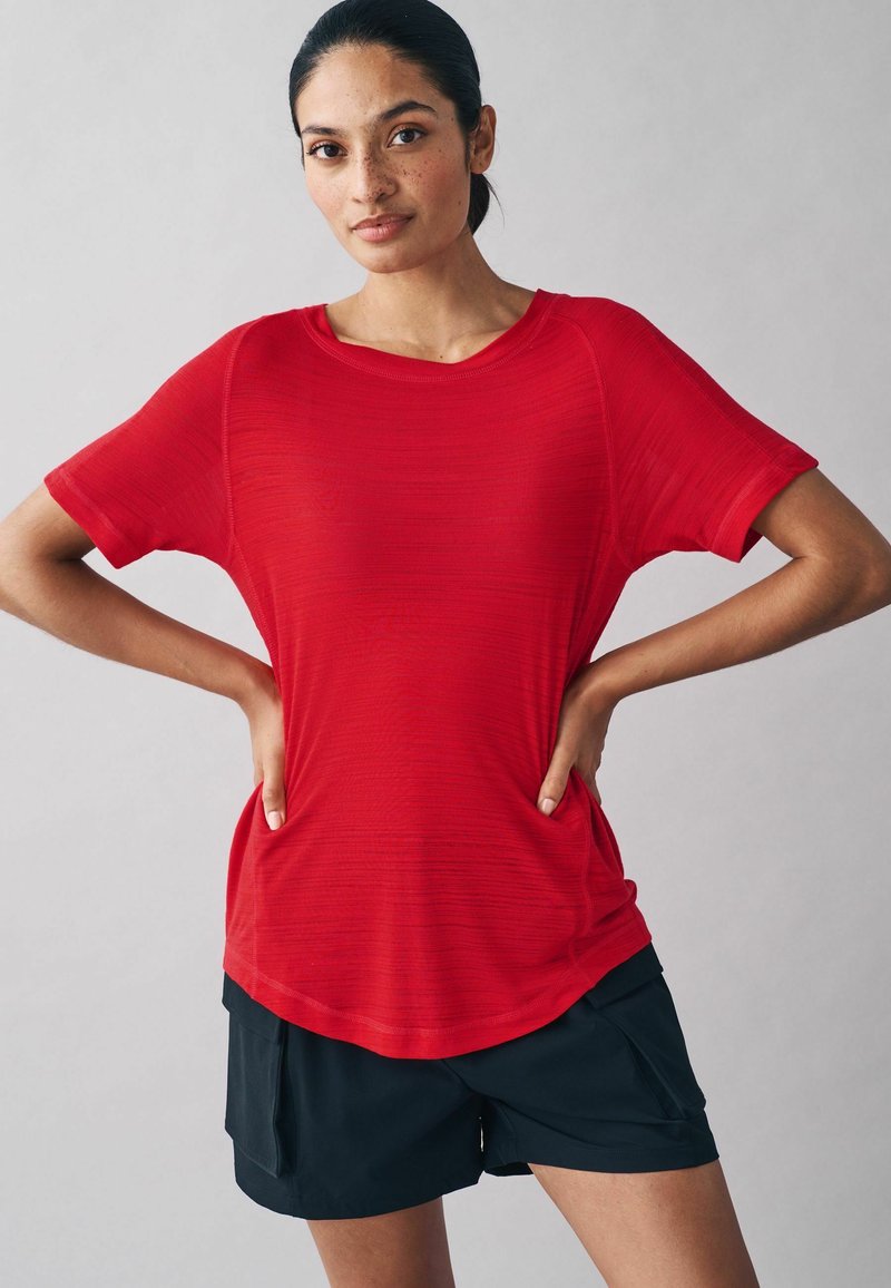 Rood sportshirt met korte mouwen, een textuurafwerking en een relaxte pasvorm, gecombineerd met zwarte shorts met zakken en een losse zoom.