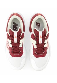 Scarpe da ginnastica rosse e bianche realizzate in materiali mesh e pelle, con dettagli testurizzati, linguetta imbottita e lacci.