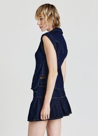 Insieme in denim scuro composto da un top aderente senza maniche con fessure laterali e una mini gonna svasata con orlo arricciato.