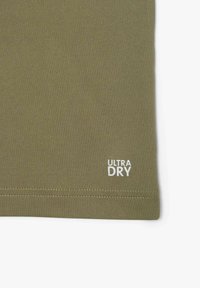 Tkanină ușoară de culoare verde măslină, cu o textură netedă. Prezintă logo-ul alb 3ULTRA DRY3 și o margine cusută. Potrivită pentru îmbrăcăminte sport.