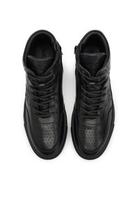 Černé kotníkové tenisky z hladké kůže s perforovanými částmi, plochými tkaničkami a jemným logem na boku.