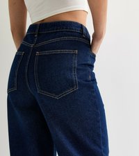 Donkerblauwe denim jeans met een klassiek vijf-pocket ontwerp, zichtbare stiksels en een hoge taille met een relaxte pasvorm.