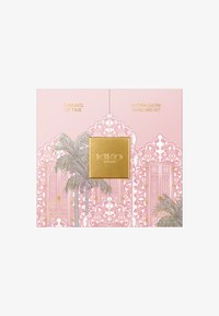 Różowe opakowanie zestawu do pielęgnacji skóry z tłoczonym na złoto logo "KIKO", ozdobnymi wzorami okien oraz ilustracjami palm z napisami "Threads of Time" i "Hydra Glow".