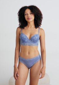 Grijze kanten lingerie set bestaande uit een gepadded beha met beugel en bijpassende slip. Zachte textuur met bloemenpatronen en ingewikkelde kantafwerking.