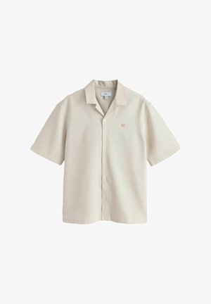 Beżowa koszula na krótki rękaw z guzikami, kołnierzem typu camp oraz małym pomarańczowym logo korony na lewej piersi.