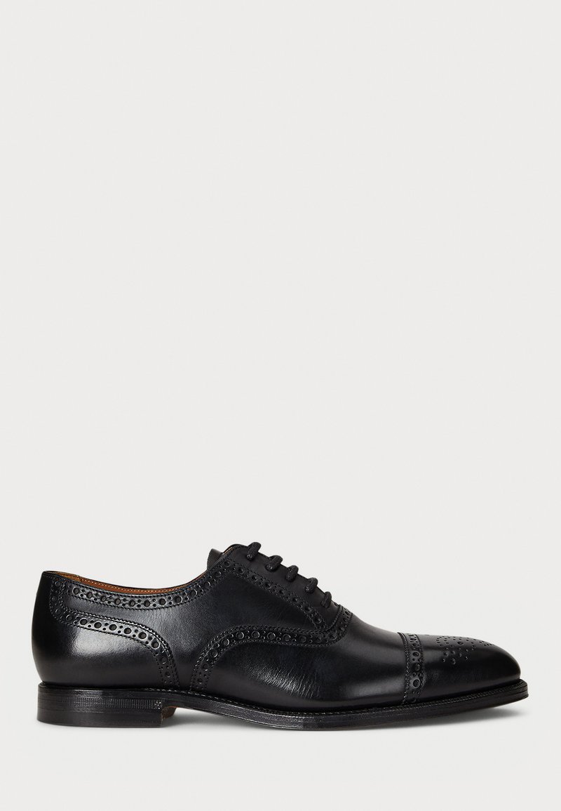 Scarpa oxford da uomo in pelle nera con dettagli brogue e chiusura con lacci, esposta su sfondo bianco.